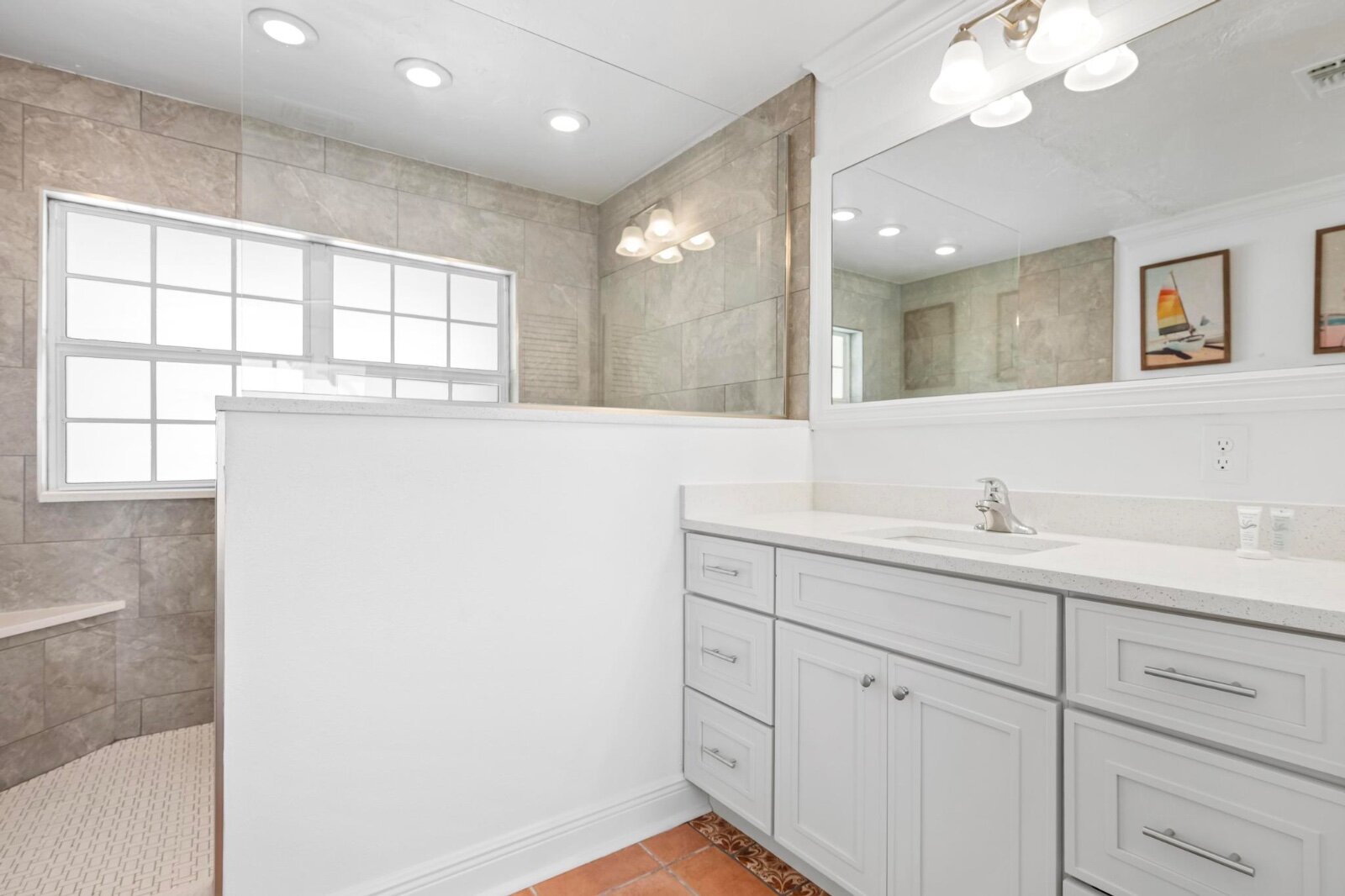 Walk-in shower with mosaic tile floor and grab bar