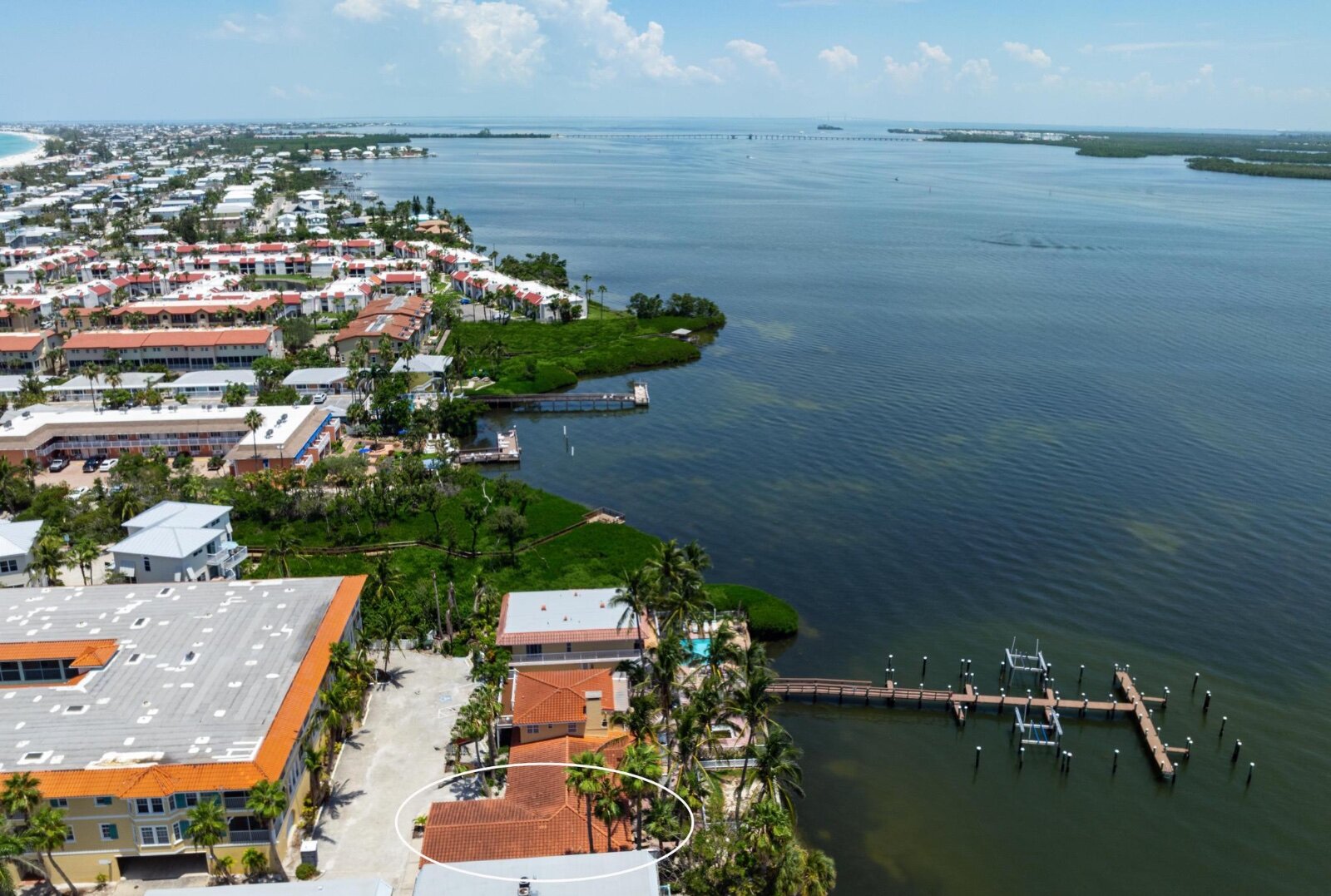 Drone aerial of Tortuga Inn with unit circled — bay to beach view