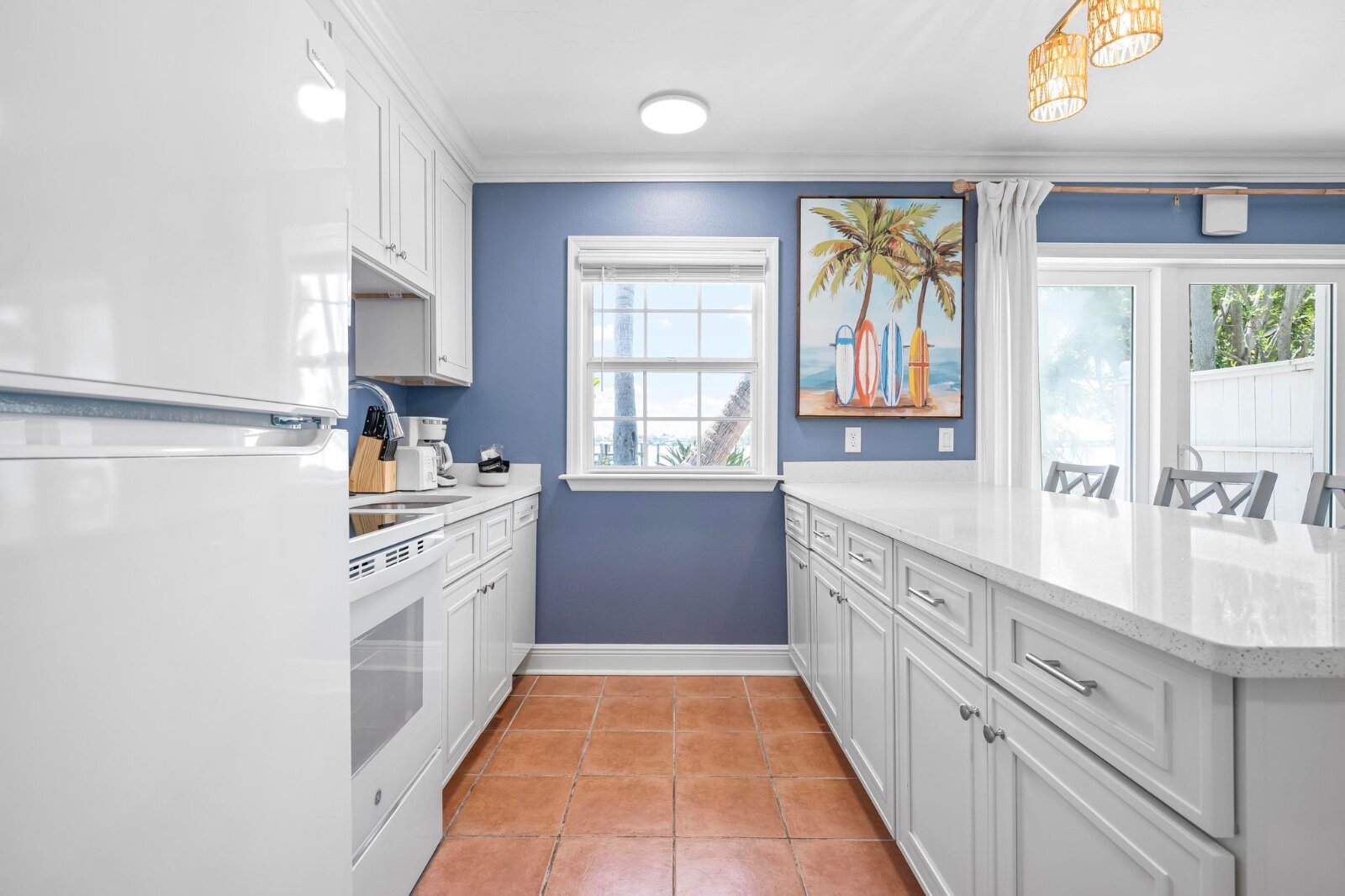 Fully equipped kitchen with blue accent wall and surfboard art